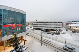 a snowy city with a christmas sign on a building at Design apartment in city center with free parking in Rovaniemi