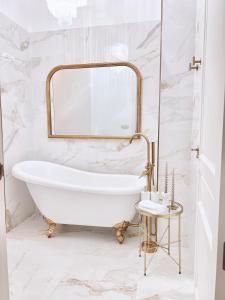 een witte badkamer met een bad en een spiegel bij Apartamento Los Burgueses in Teruel