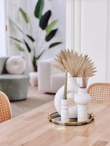 a table with two white vases with flowers on it at Apartamento Los Burgueses in Teruel