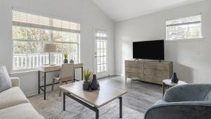 ein Wohnzimmer mit einem Sofa und einem TV in der Unterkunft Landing Modern Apartment with Amazing Amenities (ID3821X91) in Orlando