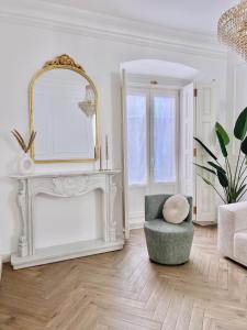 een witte woonkamer met een spiegel en een stoel bij Apartamento Los Burgueses in Teruel
