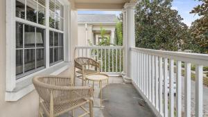 un porche con 2 sillas y una mesa en Landing Modern Apartment with Amazing Amenities (ID3821X91) en Orlando