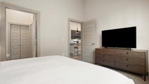 a bedroom with a bed and a television on a dresser at Landing Modern Apartment with Amazing Amenities (ID3691X72) in Austin