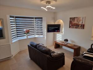a living room with a couch and a table at Dulverton house - 3 bed house /sleeps 6+ driveway+close to M1 in Nottingham
