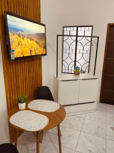 a room with two tables and a tv on the wall at Pousada Bouganville da Serra in Serra de São Bento