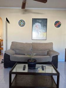 uma sala de estar com um sofá e uma mesa de centro em Casa en las buganvillas Vera Playa em Playas de Vera