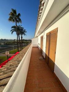 uma passagem ao lado de um edifício com uma palmeira em Casa en las buganvillas Vera Playa em Playas de Vera