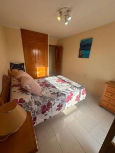um quarto com uma cama com um cobertor florido em Casa en las buganvillas Vera Playa em Playas de Vera