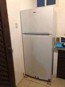 - un réfrigérateur blanc dans une cuisine à côté d'un comptoir dans l'établissement Casa de playa, en isla, frente al mar y canal, à Iztapa