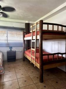 two bunk beds in a room with a fan at Casa de playa, en isla, frente al mar y canal in Iztapa