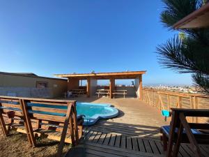 una terraza con bañera de hidromasaje, mesa y sillas en Puerto Bahia - La Herradura, en Coquimbo