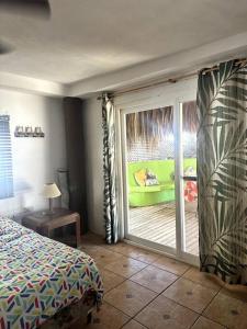 a bedroom with a sliding glass door to a patio at Casa de playa, en isla, frente al mar y canal in Iztapa