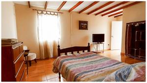 een slaapkamer met een bed en een televisie. bij ENHEBRA HOUSE in Lima