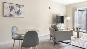 sala de estar con mesa, sillas y TV en Landing Modern Apartment with Amazing Amenities (ID1225X333) en Greenville