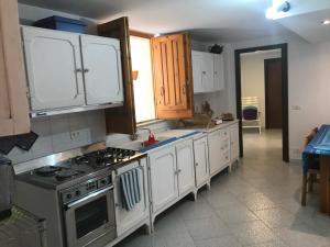 a kitchen with a stove and white cabinets at Scrusciu do Mari in Butera