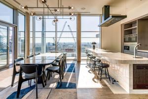 a kitchen with a long table and chairs with a view at Urban Rest Battersea Apartments in London