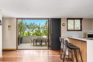 an open kitchen and dining room with a table and chairs at Byron Bay Accom Unit 6 21-25 Fletcher Street - A Seventh Heaven in Byron Bay