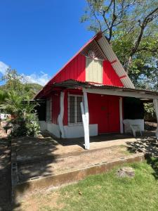a red and white house with a red roof at Las Casitas de Playa Pochote. in Pochote