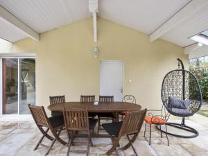 Saint-Martin-de-SeignanxにあるVilla calme avec piscine entre Pays Basque et Sud Landesのテーブルと椅子のあるダイニングルーム