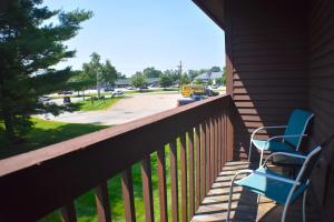 two chairs sitting on a porch with a parking lot at Fireside Inn & Suites Gilford in Gilford
