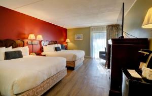 a hotel room with two beds and a television at Fireside Inn & Suites Gilford in Gilford