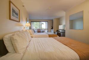 a hotel room with two beds and a living room at Aspinquid Resort in Ogunquit
