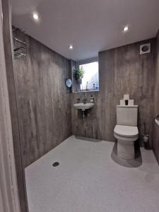 a bathroom with a toilet and a sink at Woodside House in Bexhill