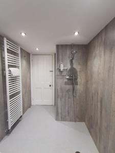 a bathroom with a shower and a white door at Woodside House in Bexhill