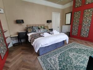 a bedroom with a bed and a red door at Woodside House in Bexhill