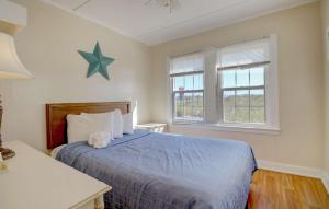 a bedroom with a blue bed and two windows at Waves Oceanfront Resort in Old Orchard Beach