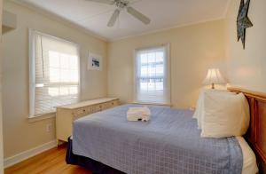 1 dormitorio con 1 cama azul y 2 ventanas en Waves Oceanfront Resort en Old Orchard Beach