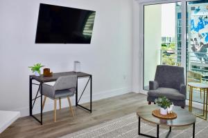 sala de estar con escritorio, 2 sillas y mesa en Landing Modern Apartment with Amazing Amenities (ID2666X14), en Fort Lauderdale