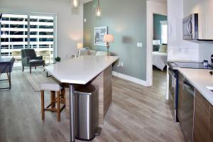 cocina y sala de estar con mesa y sofá en Landing Modern Apartment with Amazing Amenities (ID2666X14) en Fort Lauderdale