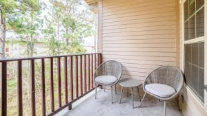 2 chaises assises sur un balcon avec une fenêtre dans l'établissement Landing Modern Apartment with Amazing Amenities (ID8014X44), à Covington