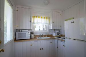 a kitchen with a white refrigerator and a microwave at The Gull Oceanfront Motel & Cottages in Old Orchard Beach