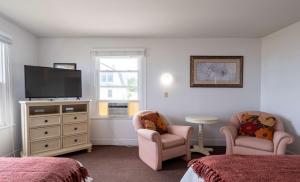 um quarto com 2 camas e uma televisão de ecrã plano em The Gull Oceanfront Motel & Cottages em Old Orchard Beach