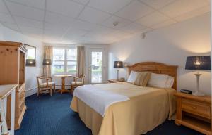 The Gull Oceanfront Motel & Cottages في أولد أوركاد بيتش: غرفة فندقية بسرير وطاولة وكراسي