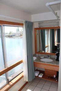 ein Badezimmer mit einem Waschbecken und einem großen Fenster in der Unterkunft Tugboat Inn in Boothbay Harbor