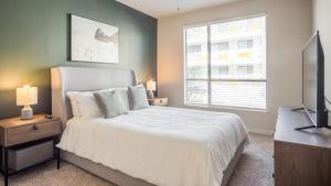 a bedroom with a bed and a television and a window at Landing Modern Apartment with Amazing Amenities (ID5072X49) in Austin