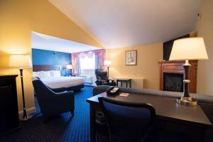 a hotel room with a bed and a desk with a desk at Fireside Inn & Suites Waterville in Waterville