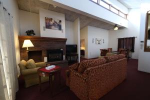 un soggiorno con divano e camino di Fireside Inn and Suites Bangor a Bangor