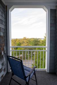 a blue chair sitting on a balcony with a large window at Bluenose Inn - Bar Harbor Hotel in Bar Harbor