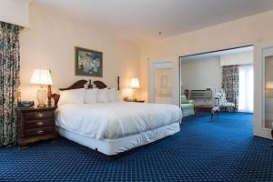 a bedroom with a large bed and a living room at Bluenose Inn - Bar Harbor Hotel in Bar Harbor