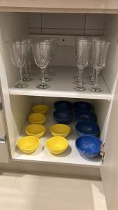 a drawer filled with different colored bowls and wine glasses at Apartamento Luxo em Uberaba in Uberaba