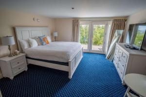 Bluenose Inn - Bar Harbor Hotel في بار هاربور: غرفة نوم بسرير وخزانة وتلفزيون