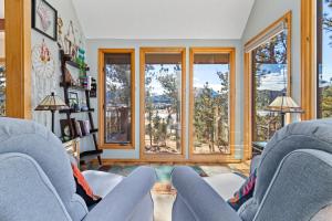 ein Wohnzimmer mit 2 blauen Stühlen und Fenstern in der Unterkunft Vista of Lake Estes by Estes Park Homes home in Estes Park