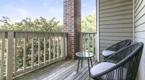 uma varanda com duas cadeiras e um pilar de tijolos em Landing Modern Apartment with Amazing Amenities (ID7025X65) em Cincinnati