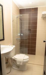 a bathroom with a shower and a toilet and a sink at Cebu Grand Hotel in Cebu City