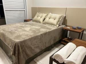 a bedroom with a large bed and two tables at Apartamento Luxo em Uberaba in Uberaba