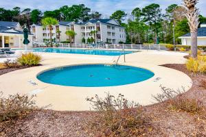a swimming pool in a yard with condos at Our Beach House Retreat in Myrtle Beach